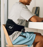 Persona con una mochila Venom 2 en la espalda mientras está sentada en un escritorio.