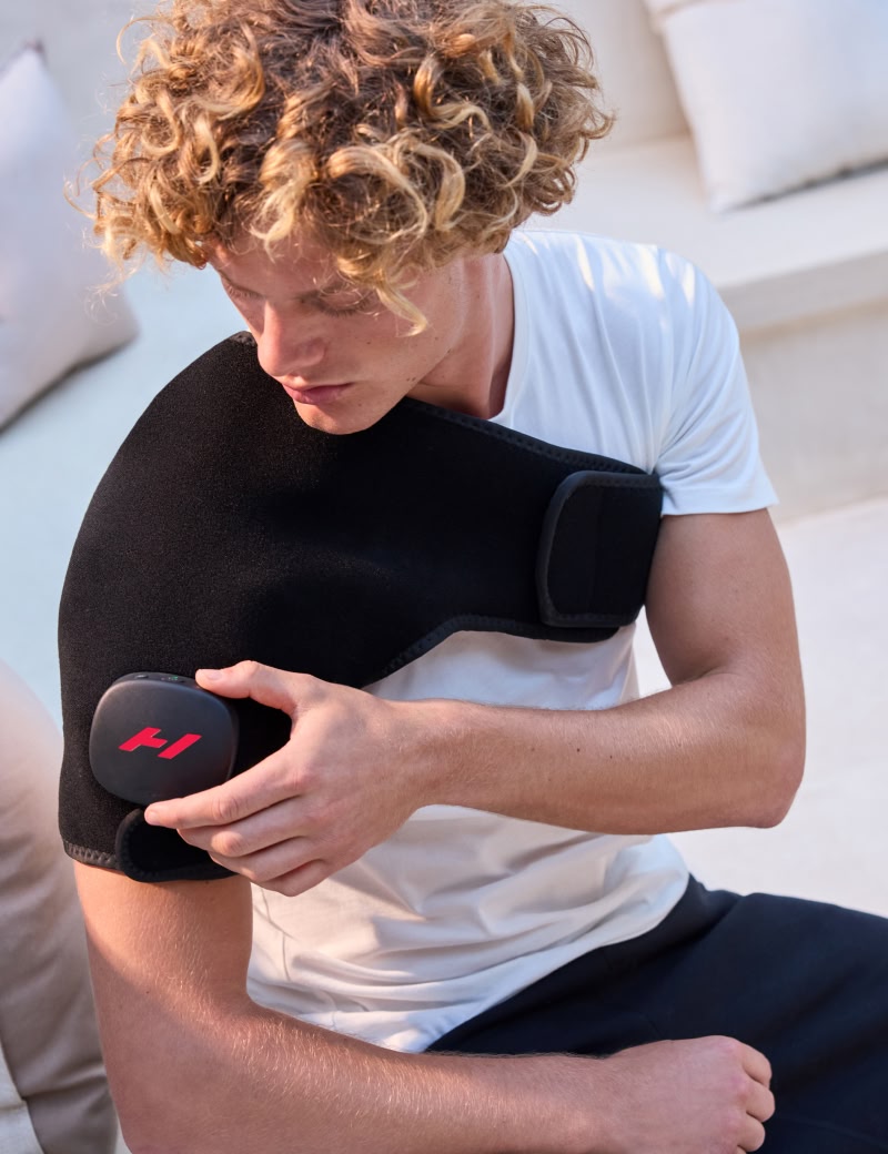 Person using a venom 2 shoulder on a light-colored couch.