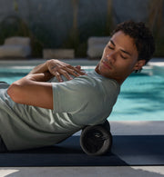 Man using a vyper 3 foam roller by a pool