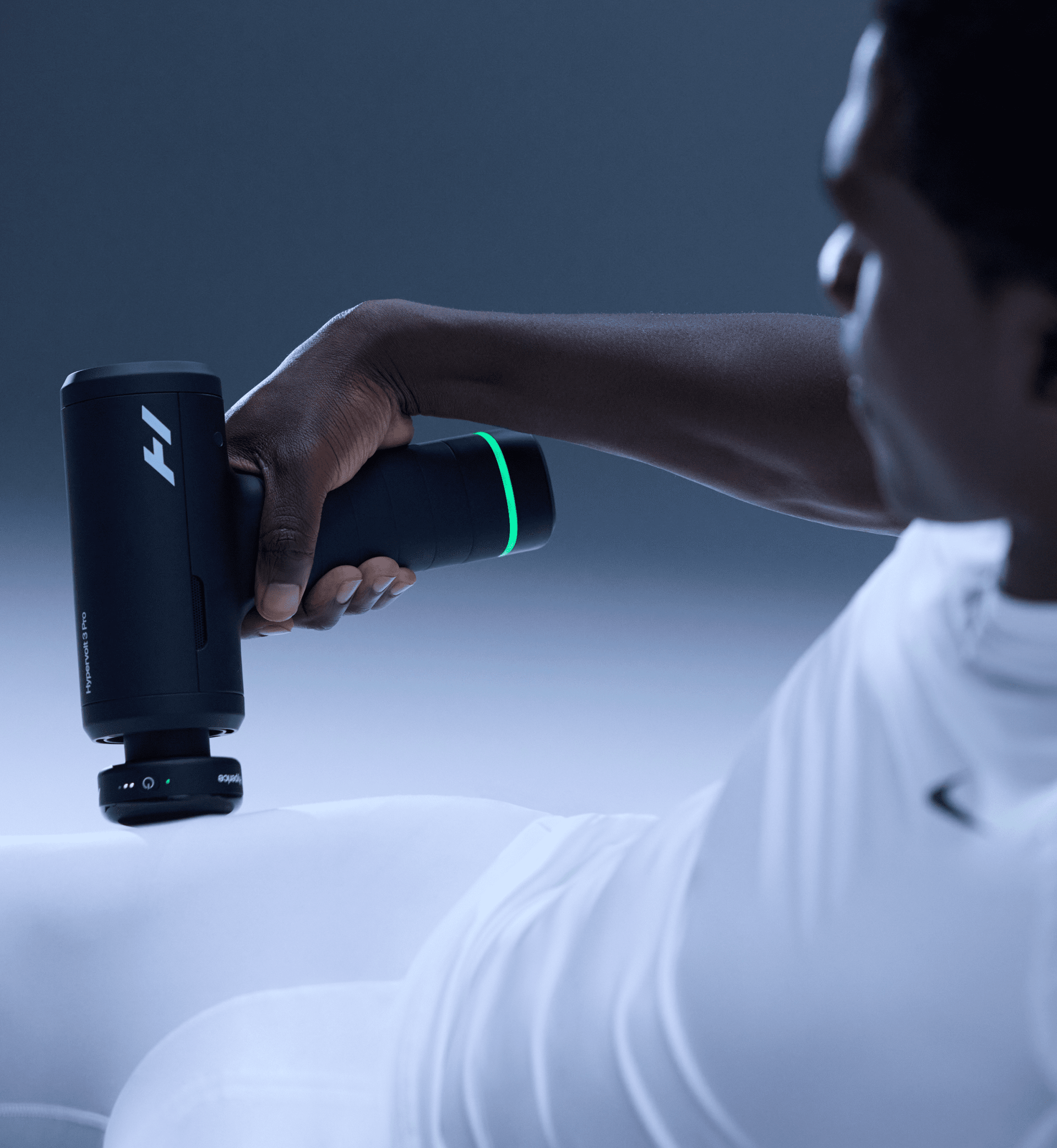 Person using a Hypervolt 3 Pro massage gun on their hip with a dark background