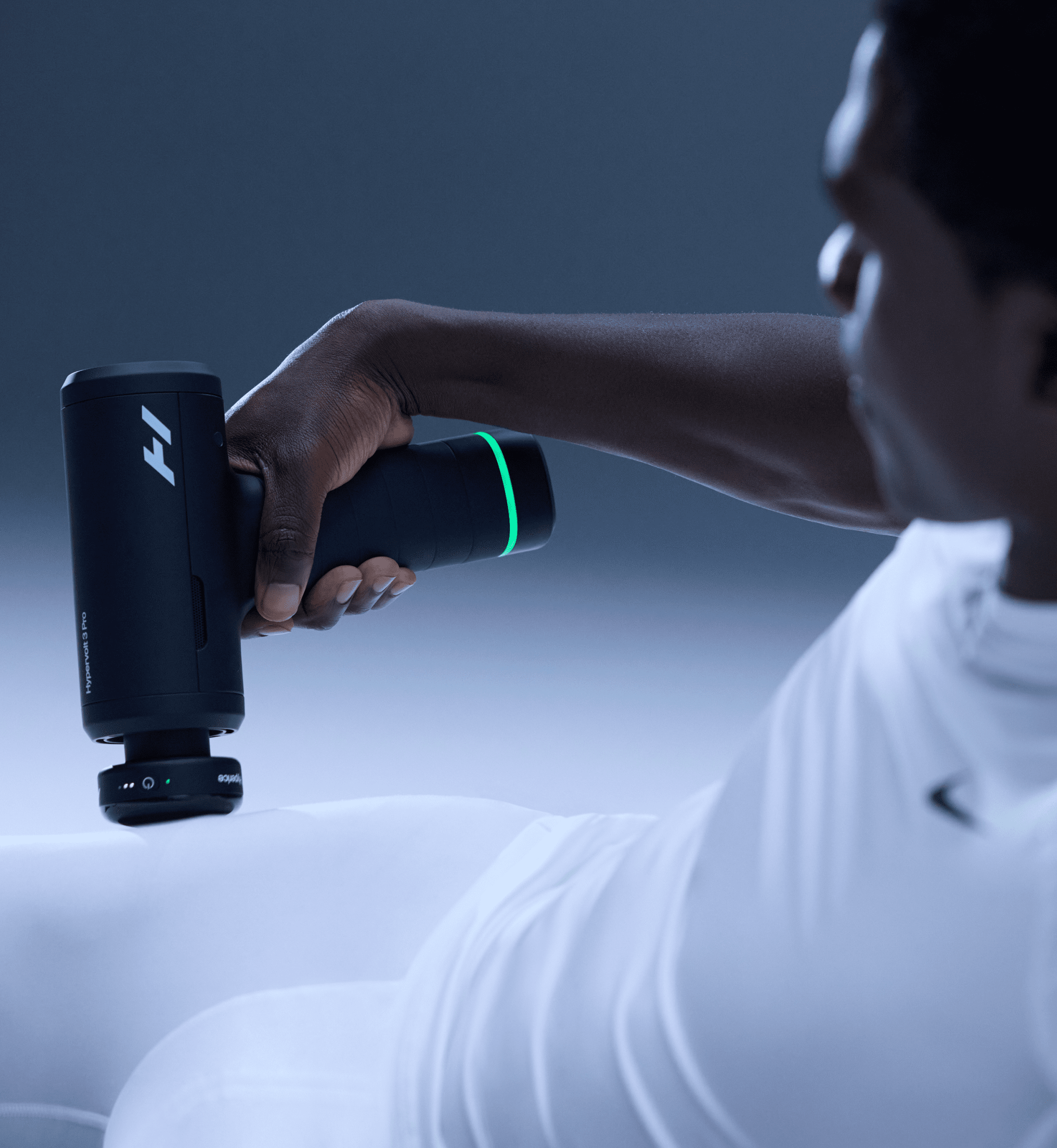 Person using a Hypervolt 3 Pro massage gun on their hip with a dark background