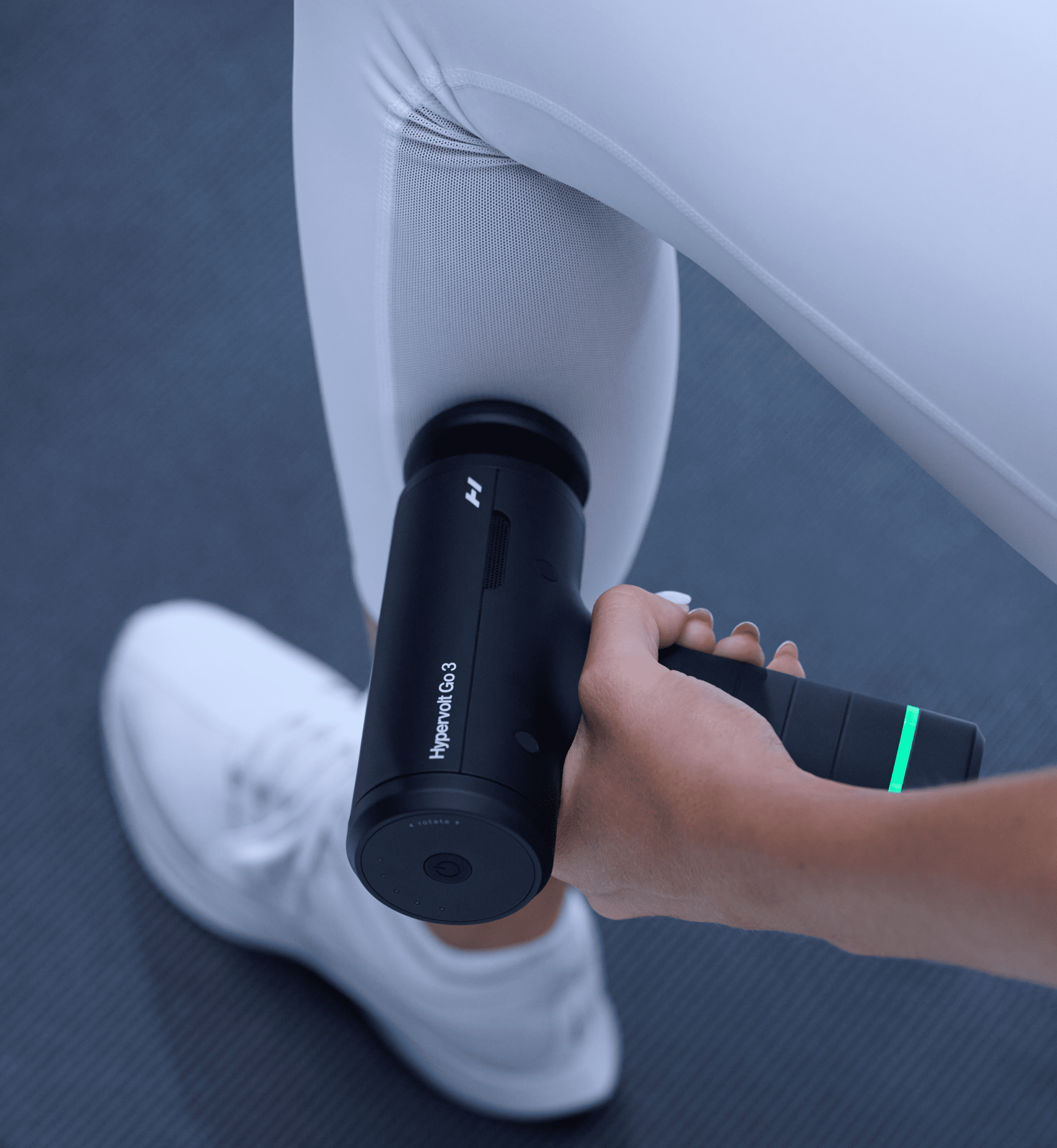 Person using a Hyperice Go 3 massage device on their leg.