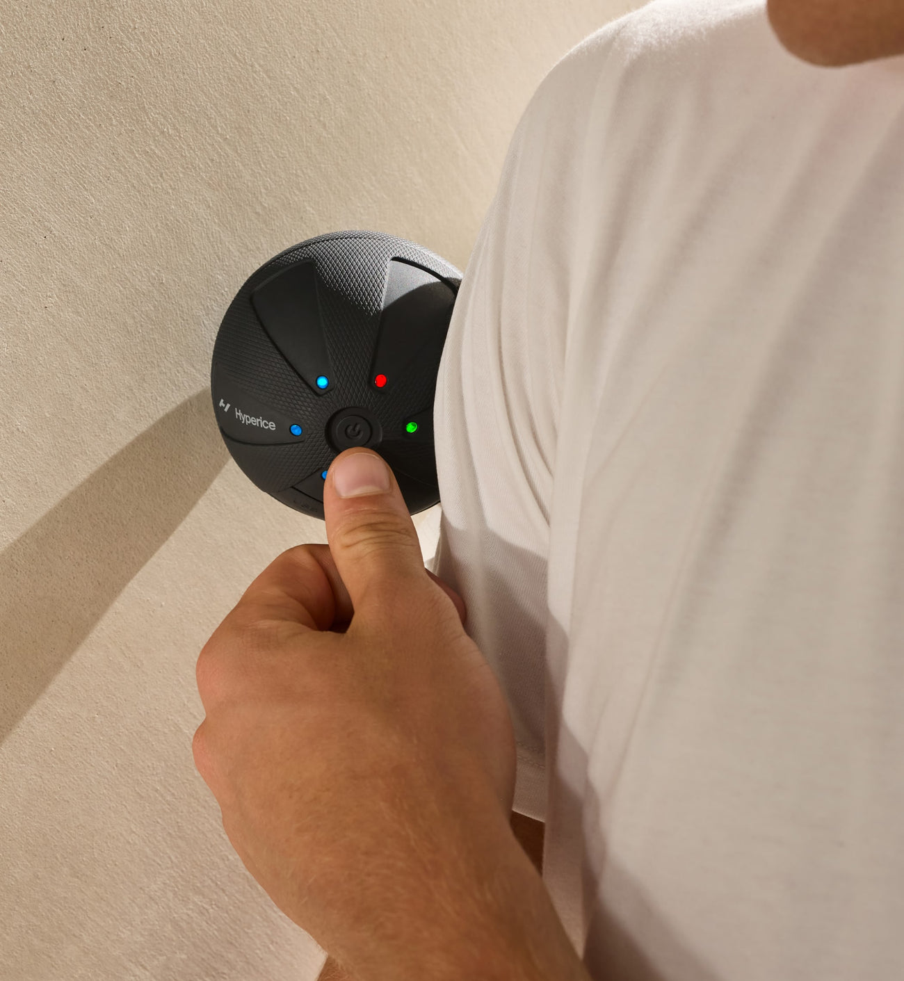 Person holding a hypersphere go with colored lights against a beige wall