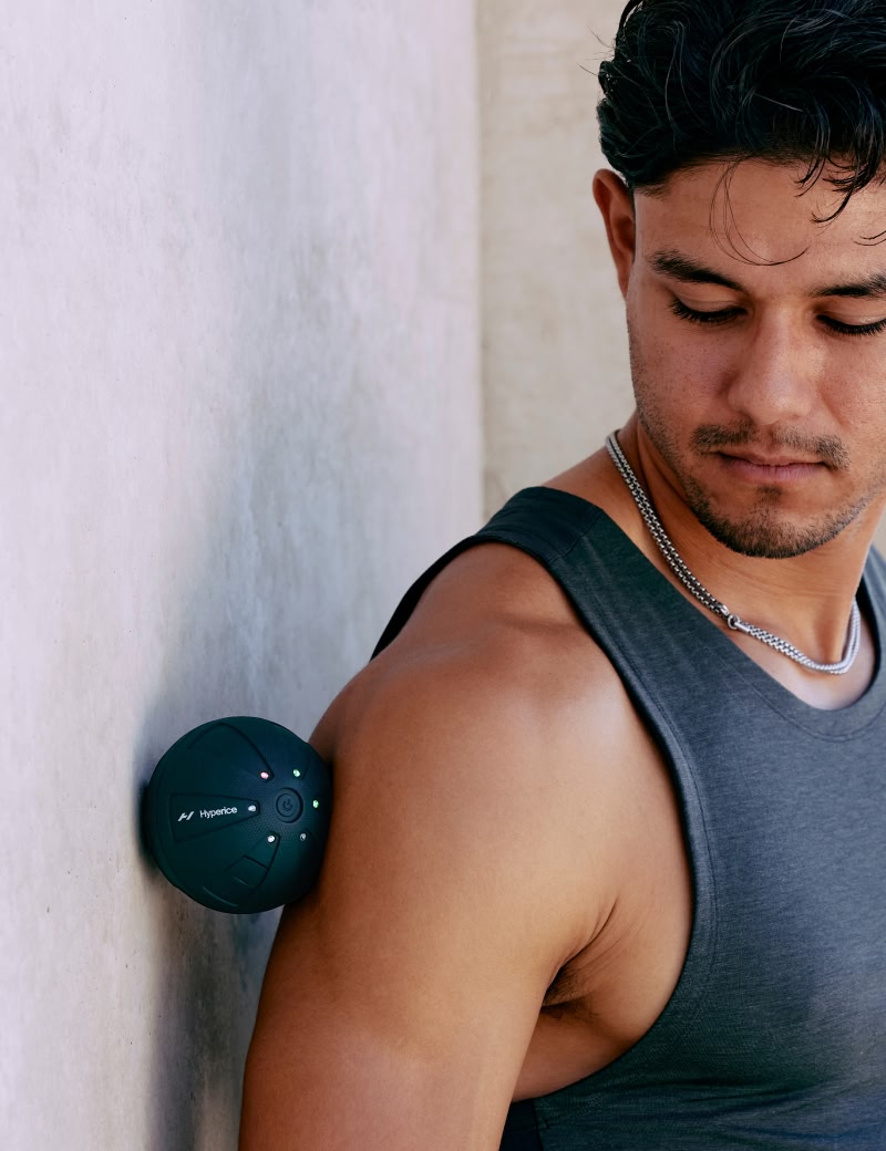 Uomo con canottiera grigia appoggiato a un muro con una ipersfera che passa tra di lui.