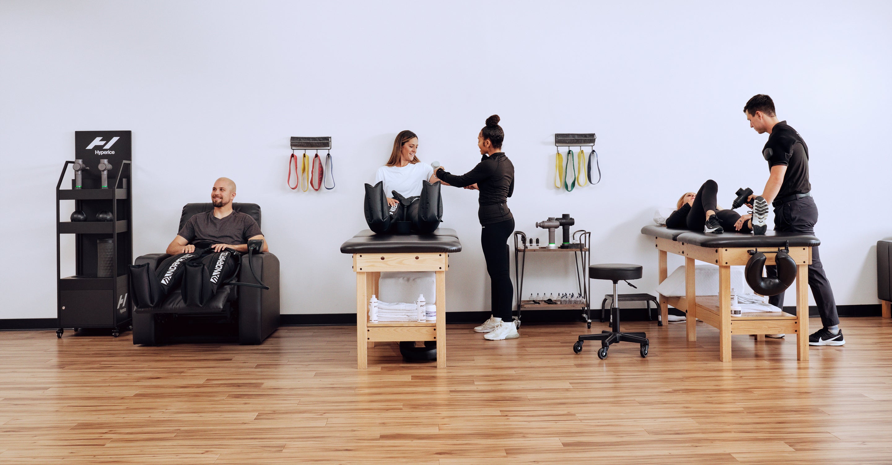 Séance de physiothérapie avec des patients et des thérapeutes dans un cabinet utilisant différentes technologies Hyperice