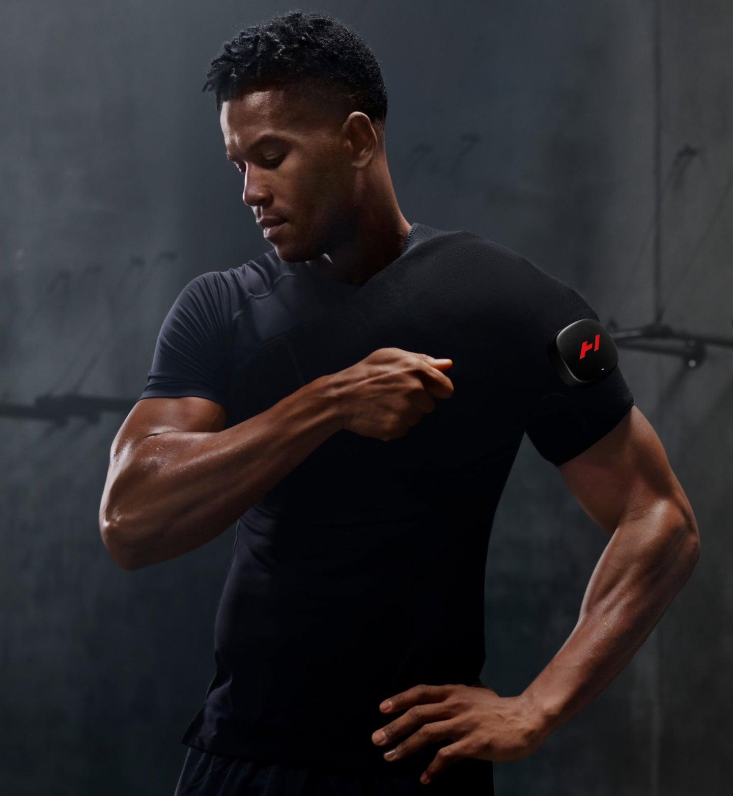 Homme portant un t-shirt noir ajustant son Venom 2 à l'épaule sur un fond sombre